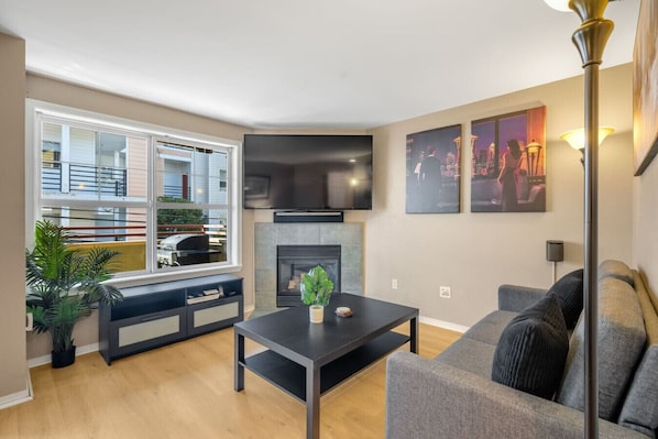 A modern living room with a fireplace, a large window, and a sofa. - 3 Bed, 2.5 Bath Fremont Escape: Hot Tub, BBQ (Seattle)