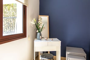 A room with a white desk, a mirror, a vase with flowers, and a window with a view of greenery. - Mia 1-BR Apartment & Balcony in Larnaca (Larnaca)