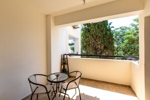 A balcony with a table and chairs, a view of trees, and a railing. - Mia 1-BR Apartment & Balcony in Larnaca (Larnaca)