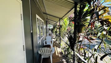 Un espacio al aire libre techado con sillas y plantas en macetas.