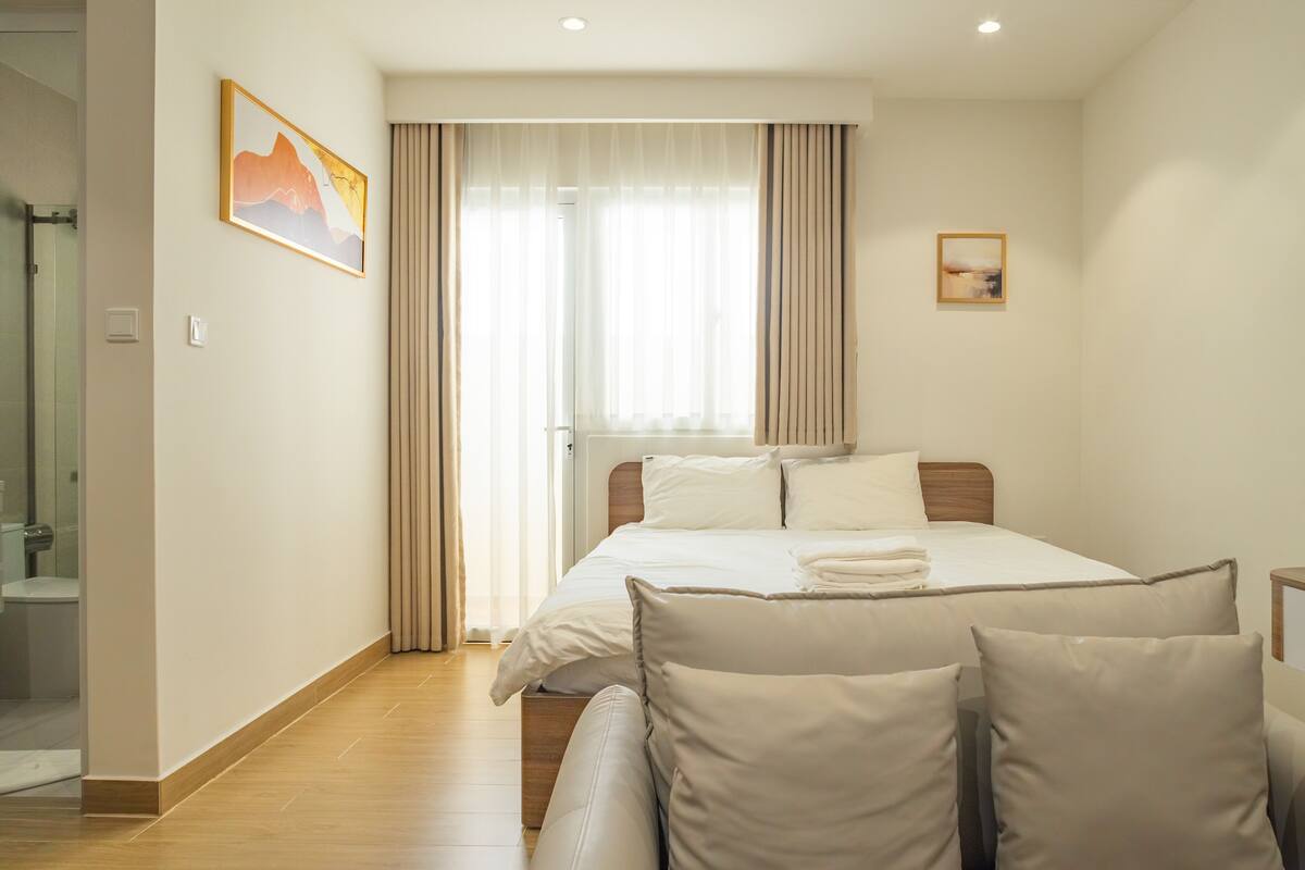 Una camera d'albergo con un letto, una doccia e un quadro appeso al muro.