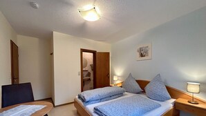 A bedroom with a bed, bedside tables, a desk, and a chair. - Cozy vacation apartment with balcony - 2 bedrooms with 2 private bathrooms (Erden)