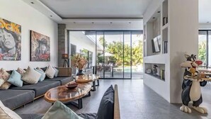 Een moderne woonkamer met een bank, salontafel en decoratieve objecten.