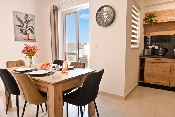 Una cocina moderna con encimera de madera, cafetera y hervidor.