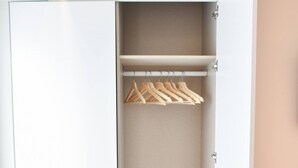 A white wardrobe with multiple shelves and hanging space. - Typical Quarter Nest (Oporto)