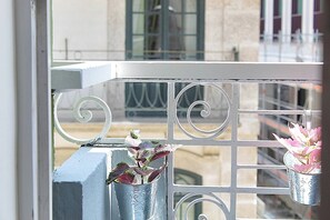 Ein Balkon mit Metallgeländern und zwei Blumenampeln.