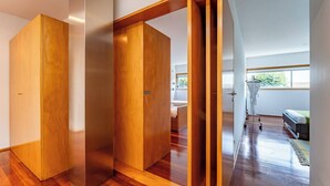 Un interior moderno con puertas correderas de madera, una cama a la vista y un ventanal.