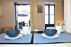 A dining table with two blue bowls, a white mug, and a clear glass container with a spoon. - Oporto Wine Cellars Flat With Terrace (Vila Nova de Gaia)