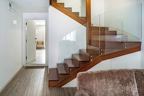 A modern staircase with glass railings and wooden steps, leading to an open doorway. - Oporto Wine Cellars Flat With Terrace (Vila Nova de Gaia)