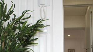 A room with a bed, a bedside table, a lamp, and a wall-mounted telephone. - Valbom Hideaway Light, Style and Peace (Valbom)