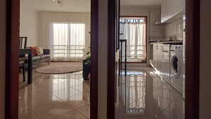 Un apartamento moderno con sala de estar, cocina y lavandería.