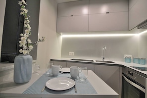 A modern kitchen with a central island, a built-in oven, and a sink. - RestOnDouro Oporto Studio (Valbom)