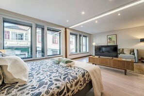 A modern bedroom with a large bed, a TV, and a sofa. - Art & Design Apartment Oporto (Oporto)