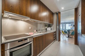 Eine moderne Küche mit Holzausstattung, Edelstahlgeräten und einem Essbereich mit Tisch und Stühlen.