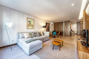 A modern living room with a sofa, coffee table, floor lamp, and artwork on the wall. - Art & Design Apartment Oporto (Oporto)