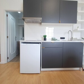 A modern kitchen with a built-in dishwasher, dark cabinetry, a window, and a sink. - Your Home in Porto 1480 Style and Confort (Oporto)