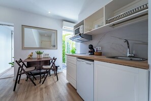 Eine moderne Küche mit weißen Schränken, einem Holztisch und einem großen Spiegel.
