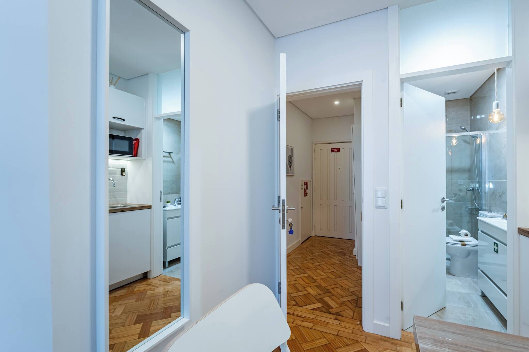 A modern apartment with a kitchen, a dining area, and a bathroom.