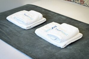 Two folded white towels with 'Jung Hotel' text on a grey carpet. - New Alegria in Town 2 (Oporto)