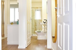 Een badkamer met toilet, douche en spiegel.