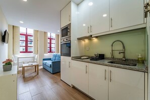 Eine moderne Küche mit weißen Schränken, einem eingebauten Backofen und einer Edelstahl-Spüle.