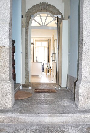 A stone staircase leading to a doorway with a glass panel, a wooden door, and a doormat on the steps. - Benskins Loft Oporto Downtown (Oporto)