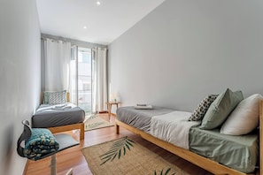 A bedroom with a bed, a chair, a small table, and a window with curtains. - Experience the Charm  Porto Apartment with Terrace (Oporto)