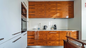 Een keuken met houten kastjes, een roestvrijstalen oven en een koffiezetapparaat.