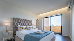 Een moderne hotelkamer met een groot bed, een nachtkastje, een spiegel en uitzicht door een schuifdeur.