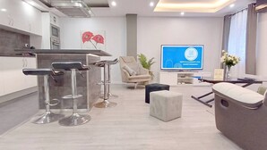 Ein modernes Interieur mit Barbereich, Sitzgelegenheiten und einem Fernseher, der ein Logo zeigt.