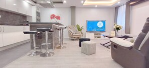 Ein modernes Interieur mit Barbereich, Sitzgelegenheiten und einem Fernseher, der ein Logo zeigt.