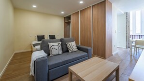 Ein modernes Wohnzimmer mit grauem Sofa, Holzschrank und Couchtisch aus Holz.