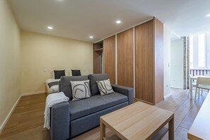 A modern living room with a grey sofa, wooden wardrobe, and a wooden coffee table. - Close to Everything Your Oporto Gray PRM 2T (Porto)