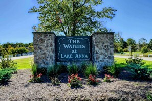A sign for 'The Waters at Lake Anna' with a stone wall and landscaping. - Lakefront Luxury 7BR, 7BA, Beach, Dock, Views (Mineral)