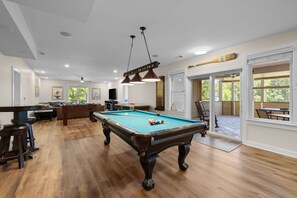 A pool table in a room with a wooden floor, a ceiling fan, and a door leading to an outdoor patio. - Lakefront Luxury 7BR, 7BA, Beach, Dock, Views (Mineral)
