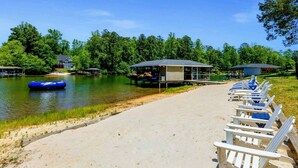 Une zone au bord du lac, avec un quai, des chaises longues et un petit bâtiment.