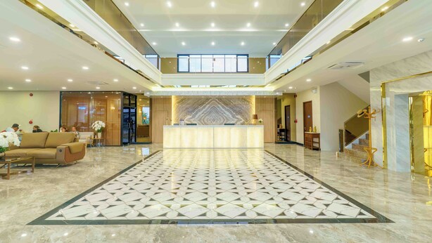 A spacious lobby with a marble floor, a reception desk, and a staircase leading to upper floors. - Sakhonburi Cozy Hotel (Samut Sakhon)