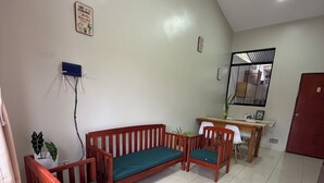 A room with a wooden sofa set, a small table, a mirror, and a tiled floor. - Relax Garden House (Moyobamba)