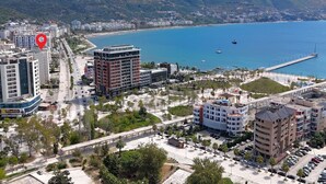 A coastal cityscape with modern buildings, a marina, and a bridge. - Ellin Apartment (Vlorë)