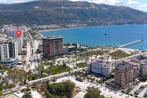 A coastal cityscape with modern buildings, a marina, and a bridge. - Ellin Apartment (Vlorë)