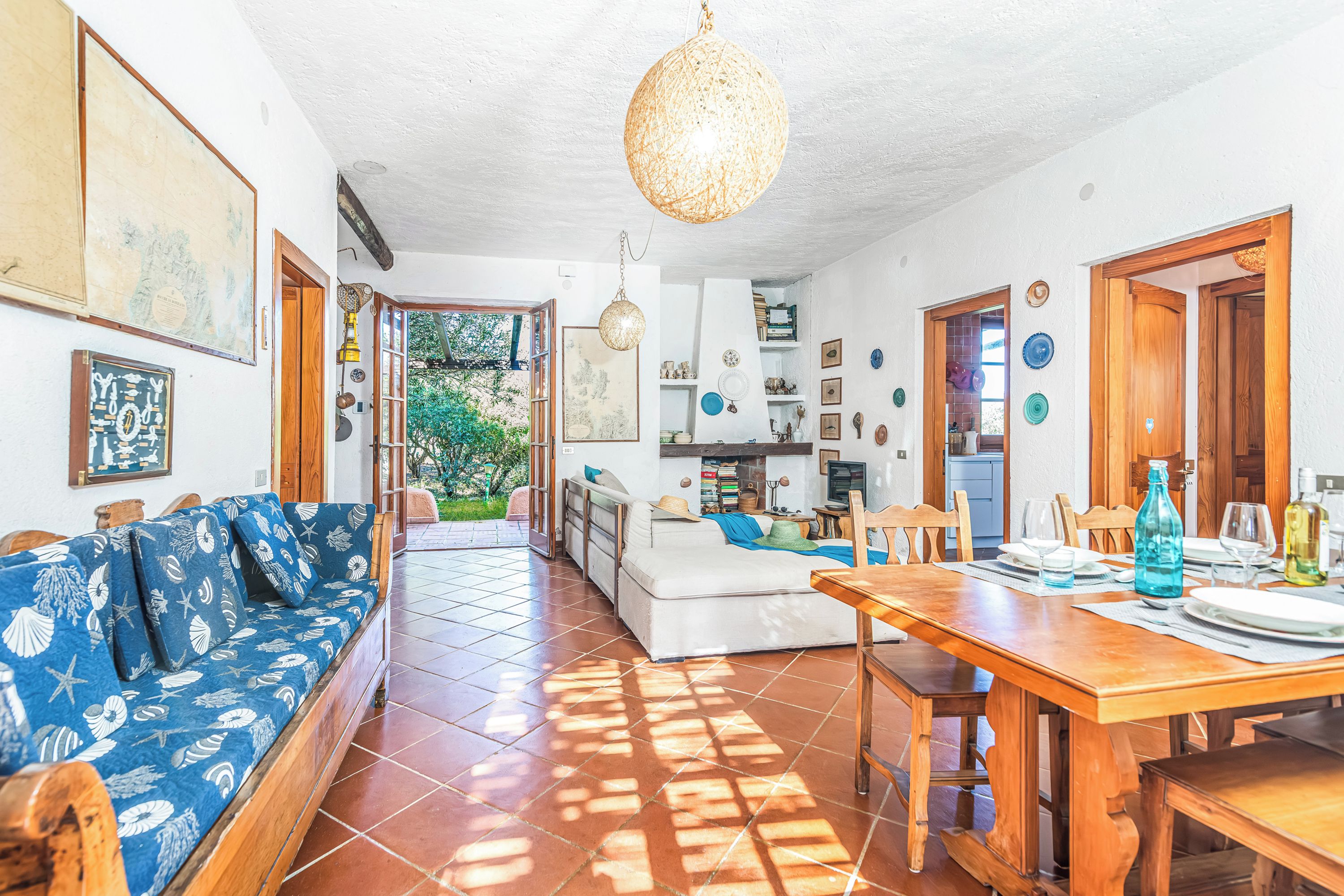 A spacious living area with a sofa, dining table, and kitchen in the background.