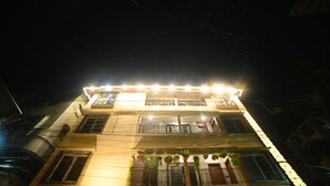 A multi-story building with balconies, visible railings, and a sign at the bottom. - ELORA'S INN (Siliguri)