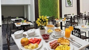 A breakfast buffet with various dishes, including fruits, eggs, and coffee. - Hotel NASS del Sur (Cuenca)