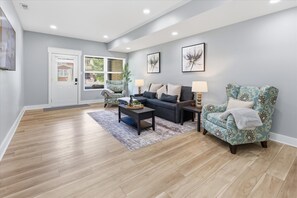 A living room with a sofa, armchair, coffee table, and two lamps. - All New 3 Story House near Downtown Indy (Indianapolis)