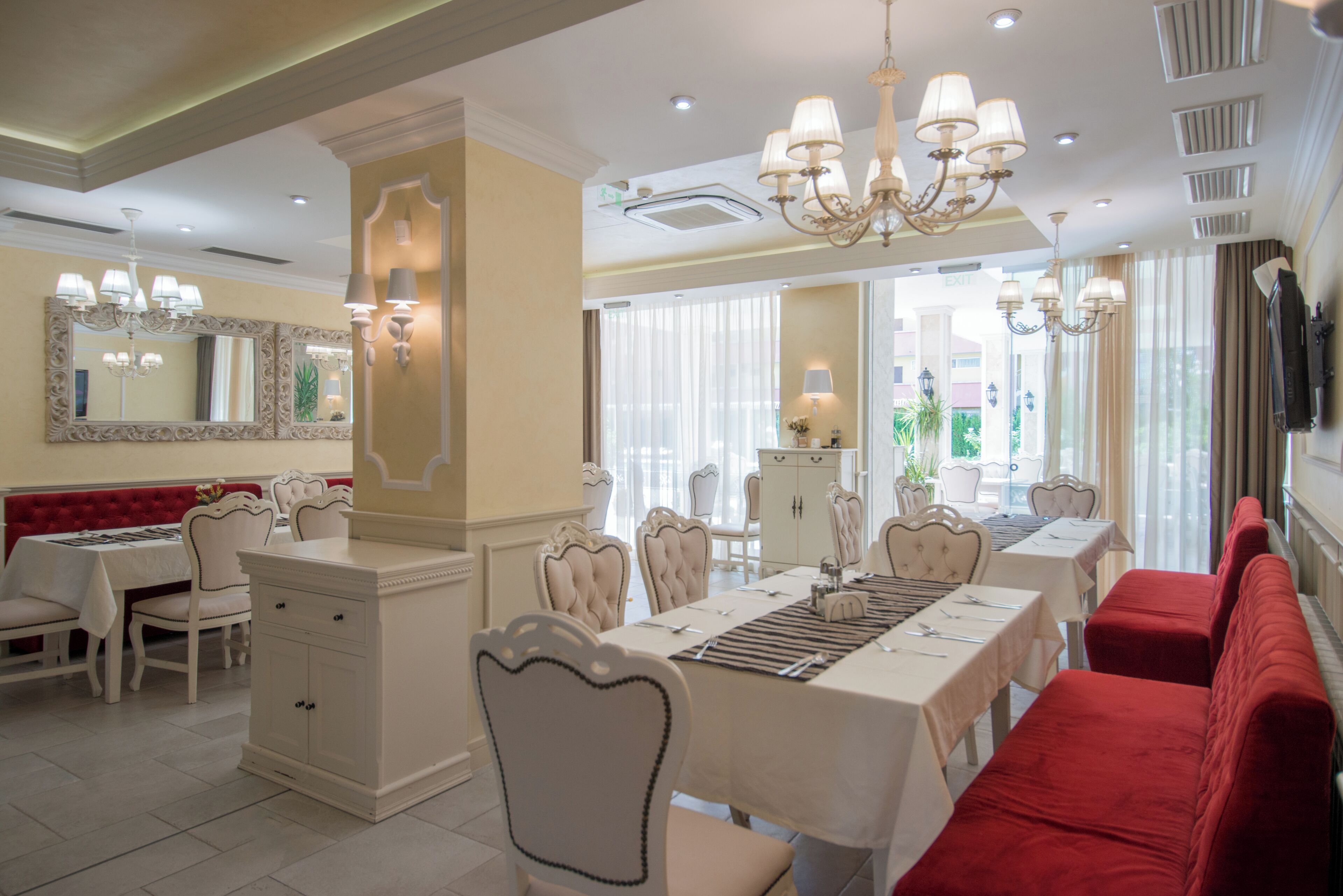 Un espace repas avec une longue table, des chaises et un banc rouge.