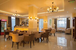 Egy hotel előtere, amelyben bár, ülőhelyek és egy Coca-Cola hűtőszekrény található.