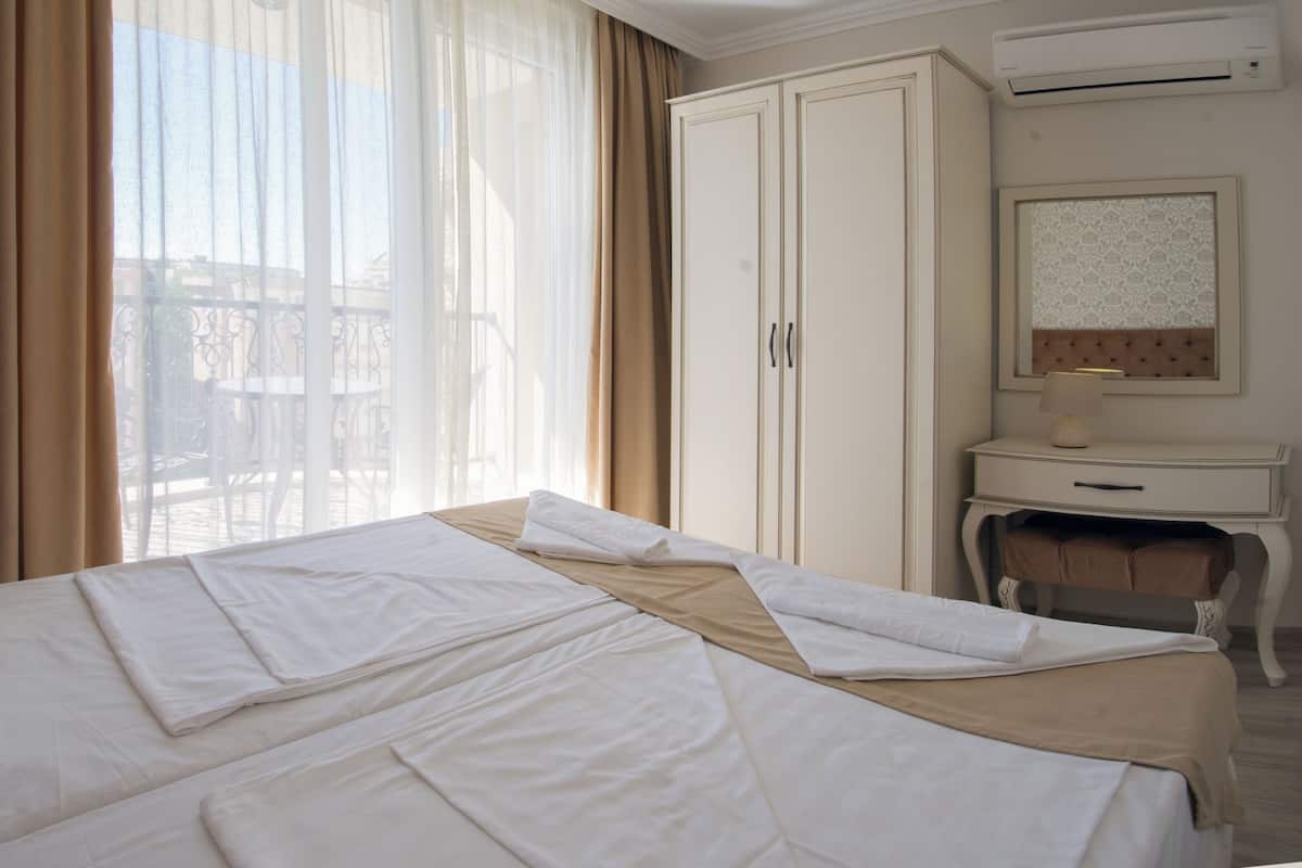 A hotel room with a bed, curtains, a desk, and a chair.