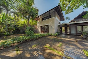 A modern house with a large garden, a paved patio, and a large window. - Villa SS Chang (Canggu)