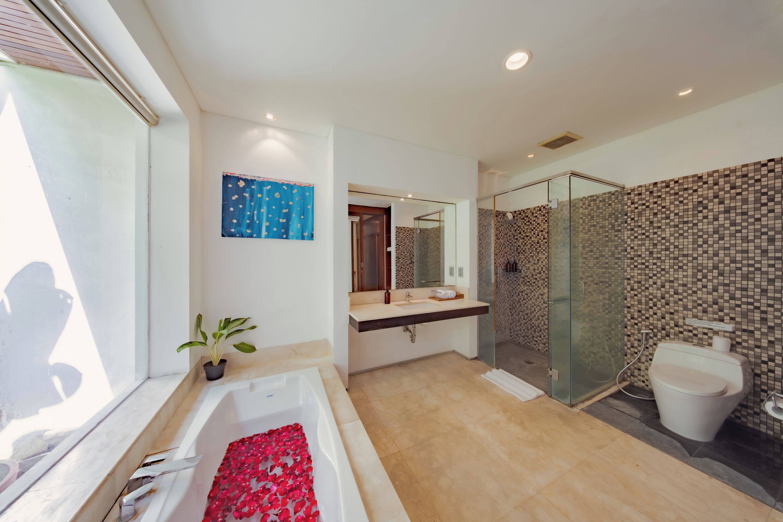 A modern bathroom with a bathtub, shower, and toilet.