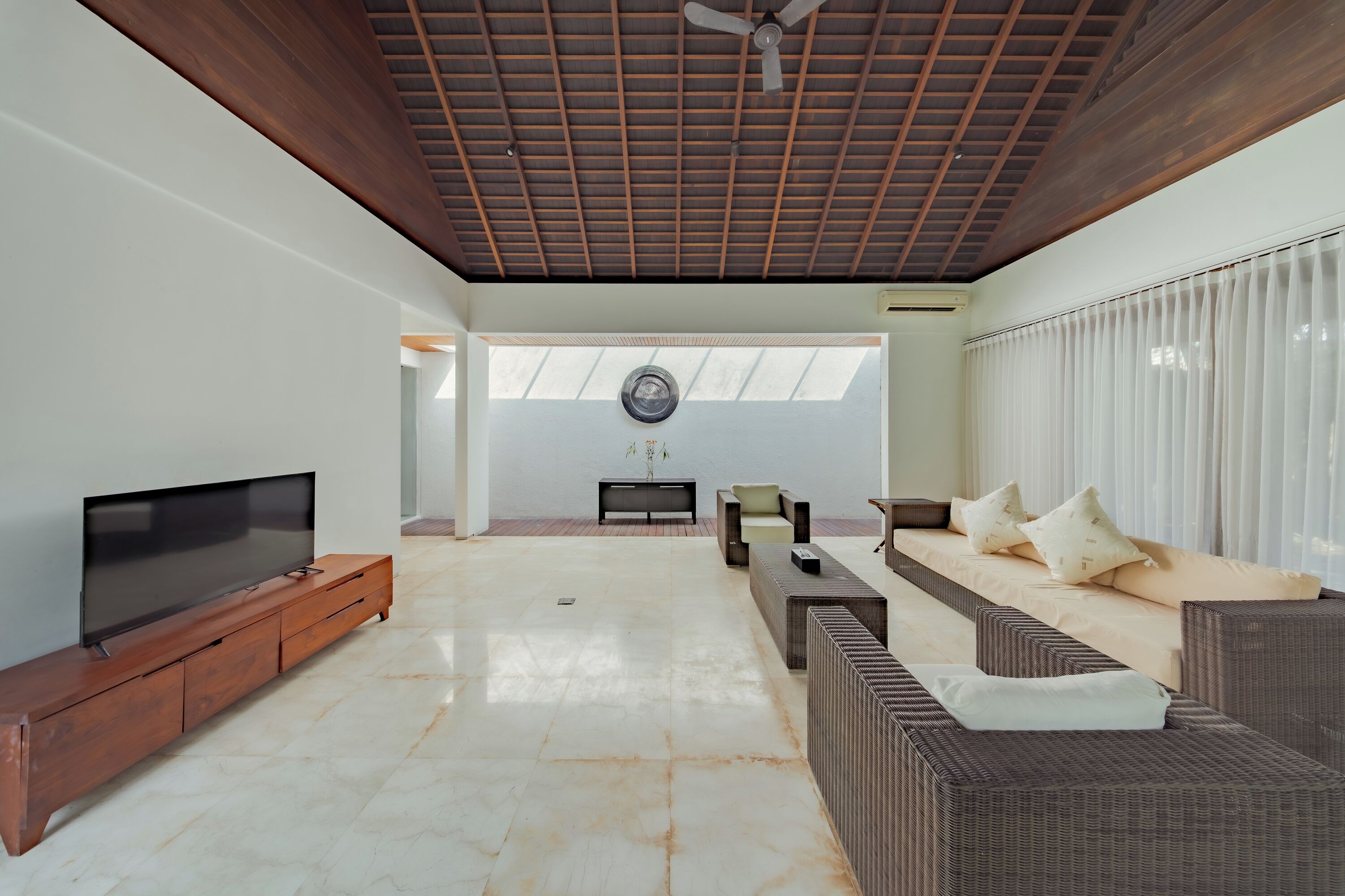 A spacious living area with a flat-screen TV, a sofa set, and a fireplace.